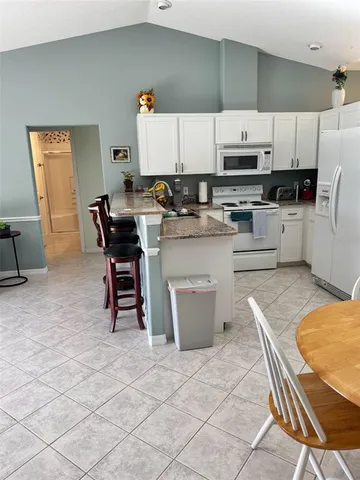 a kitchen with a sink a stove a refrigerator and cabinets