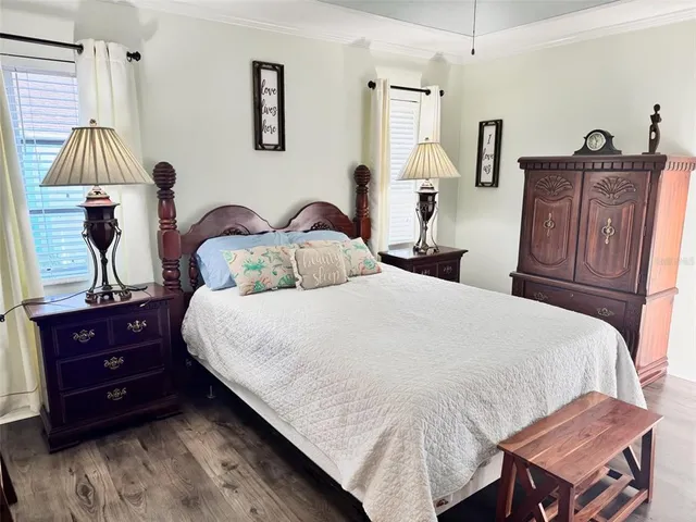 a bedroom with a bed and wooden floor