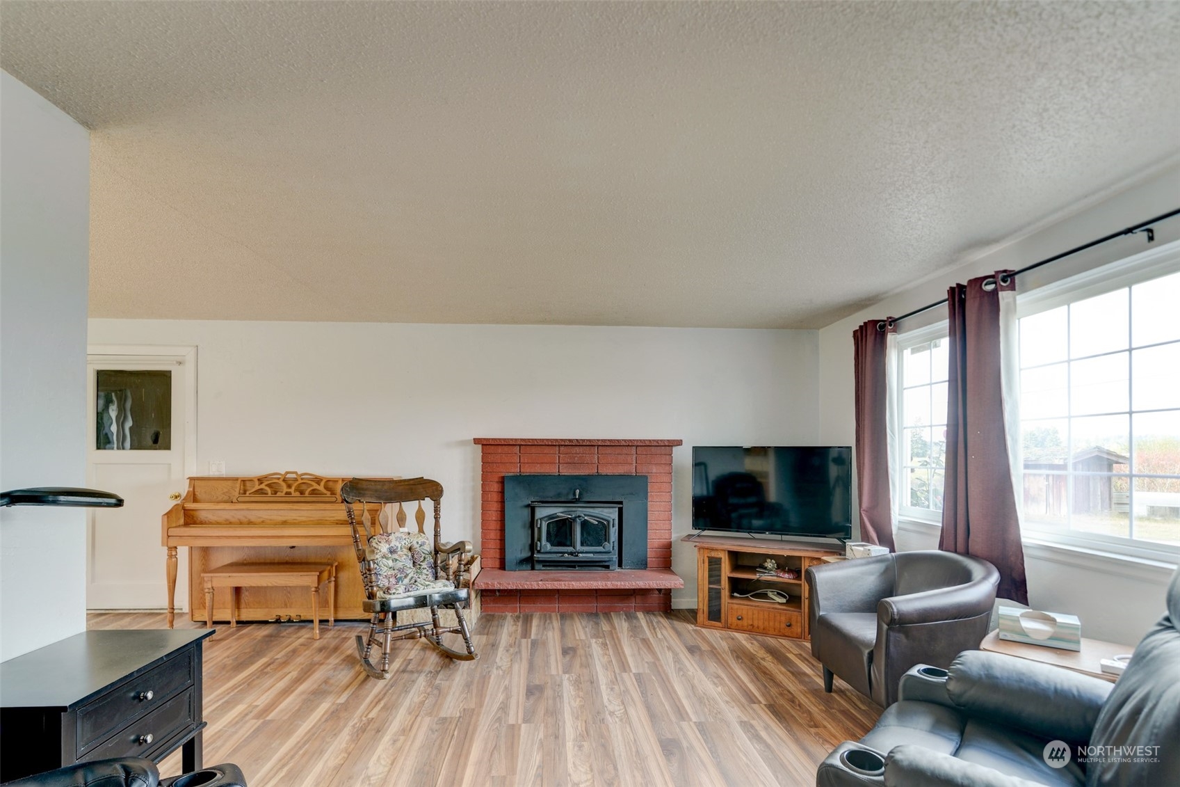 6721 183rd Avenue Southwest Rochester, WA 98579 - Photo 4 of 18 a living room with furniture a flat screen tv and a fireplace