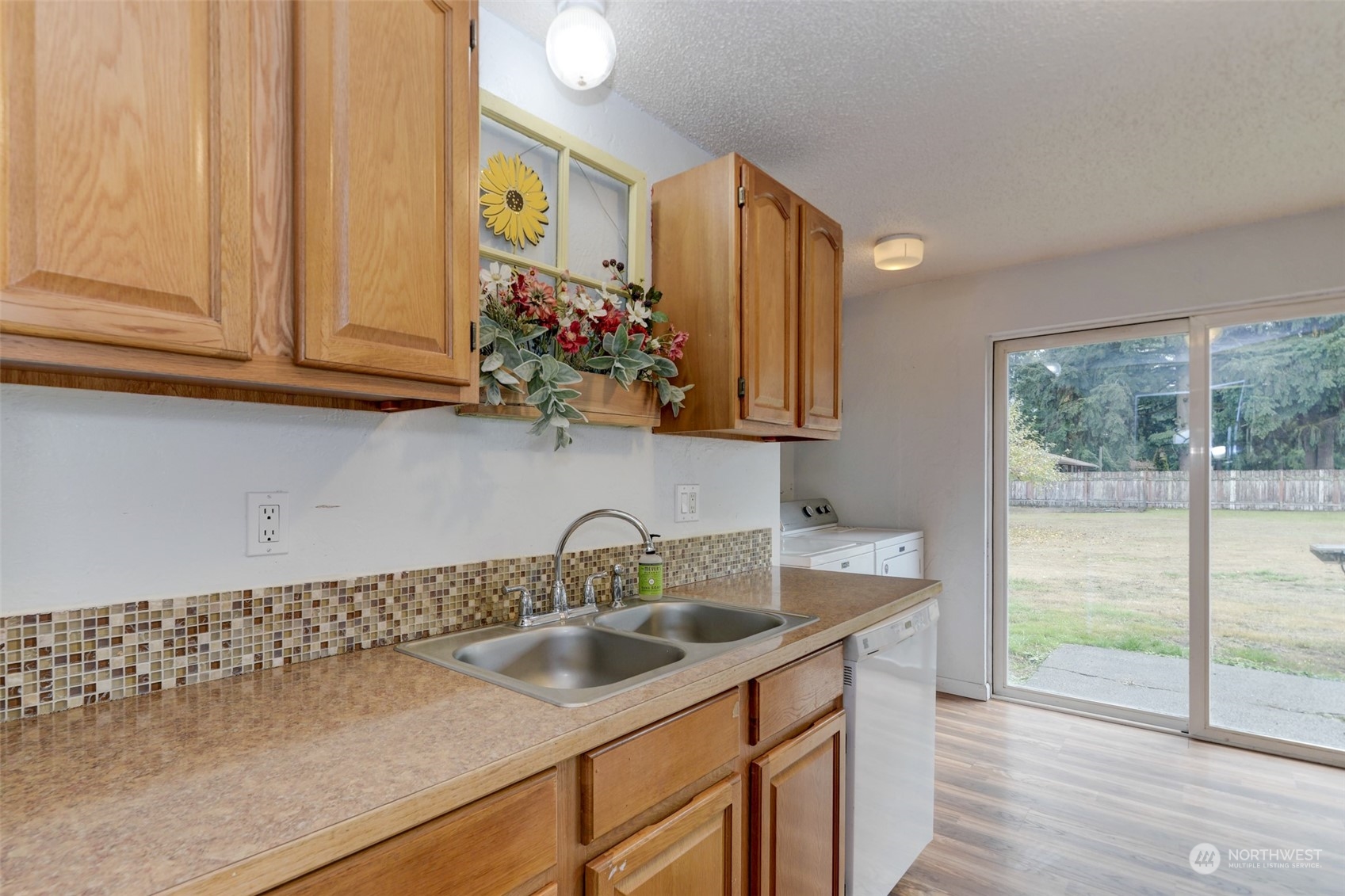 6721 183rd Avenue Southwest Rochester, WA 98579 - Photo 8 of 18 a kitchen with stainless steel appliances granite countertop a sink and a white cabinets with wooden floor