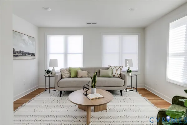 a living room with furniture and a wooden floor