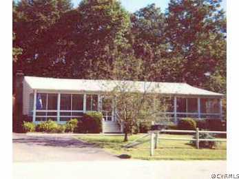 a view of a house with a small yard and large tree
