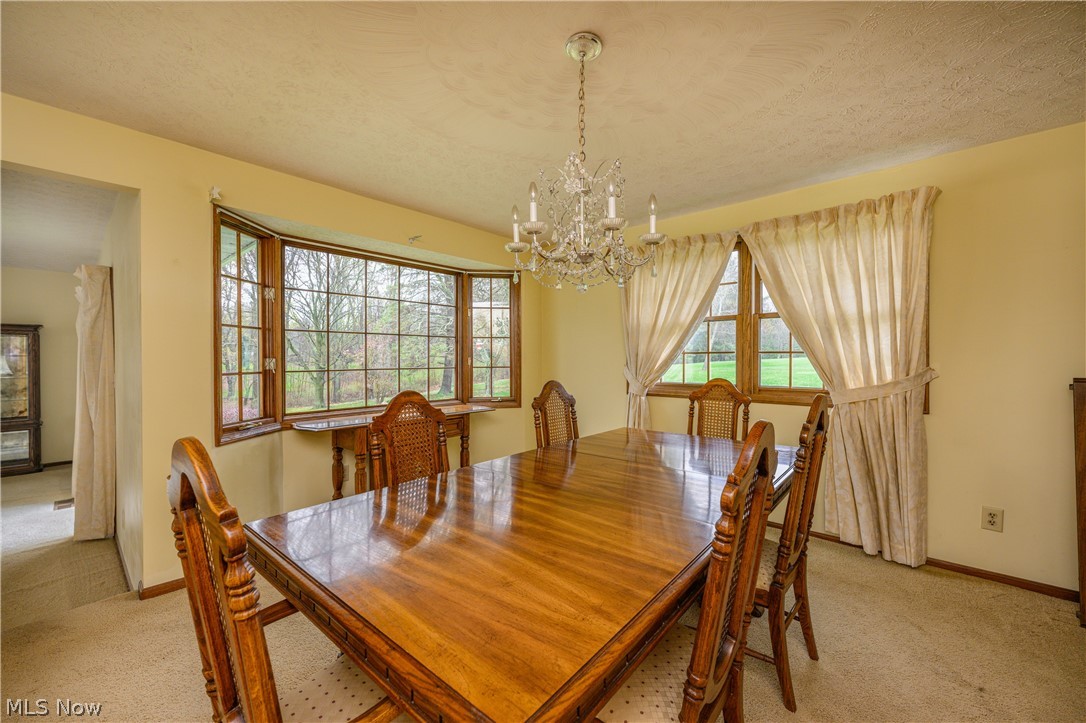 3724 Shellhart Road Barberton, OH 44203 - Photo 16 of 32 Carpeted dining space with a textured ceiling and a notable chandelier