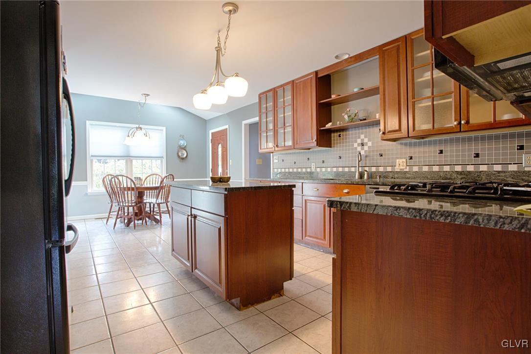 724 South Delps Road Bath, PA 18014 - Photo 6 of 23 a kitchen with stainless steel appliances granite countertop a stove top oven a sink a dining table and chairs with wooden floor