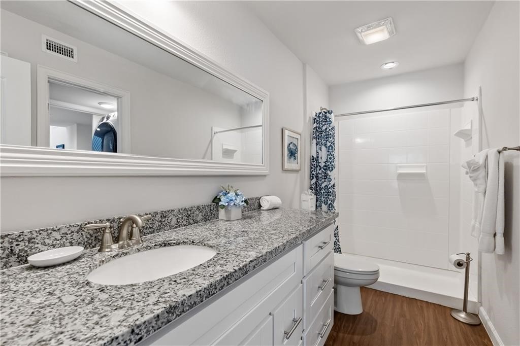 620 South Fulton Beach Road, Unit 308 Rockport, TX 78382 - Photo 13 of 30 a bathroom with a granite countertop sink a toilet and a mirror