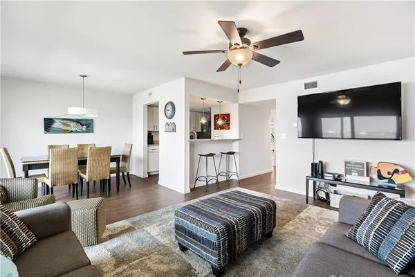 a living room with furniture kitchen view and a flat screen tv