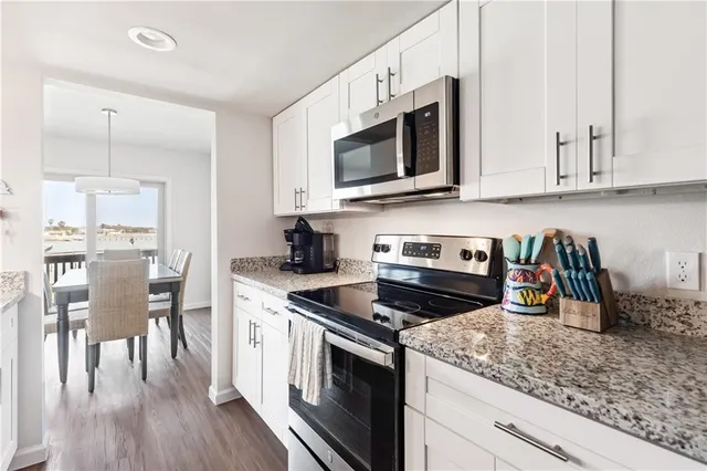 a kitchen with stainless steel appliances granite countertop a stove a microwave and cabinets