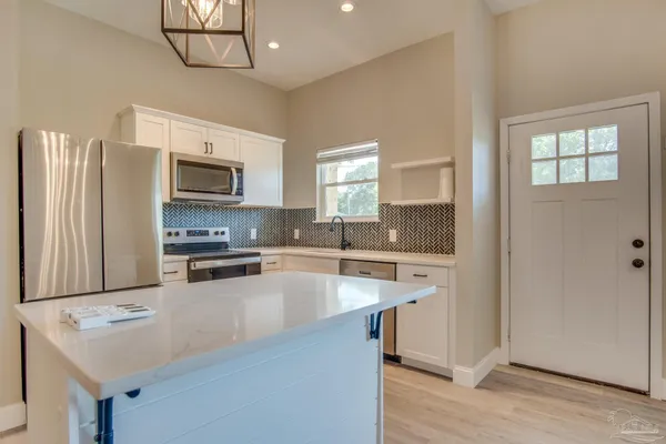 a kitchen with stainless steel appliances a stove sink microwave and refrigerator