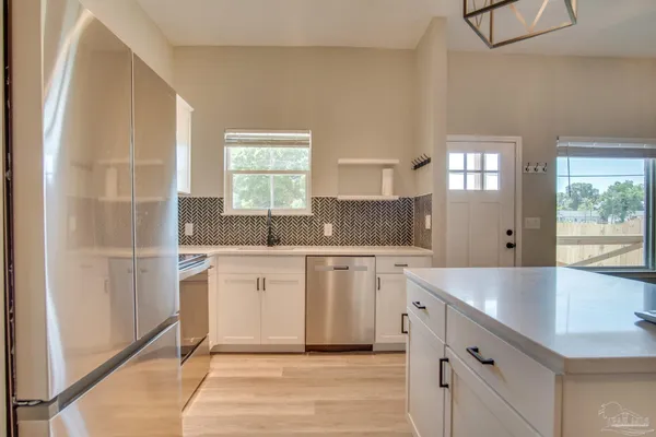 a white kitchen with sink and window