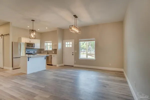 a view of kitchen with kitchen island wooden floor center island and stainless steel appliances
