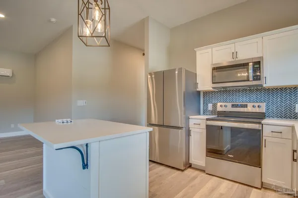 a kitchen with appliances a refrigerator and cabinets