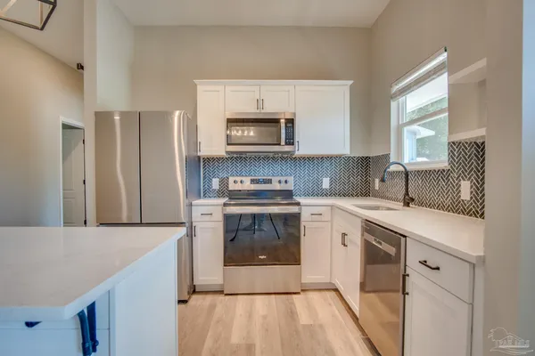 a kitchen with cabinets a sink and stainless steel appliances