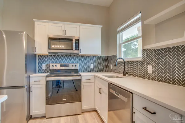 a kitchen with a stove sink and cabinets