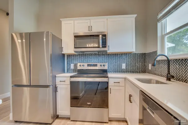 a kitchen with a stove sink and refrigerator
