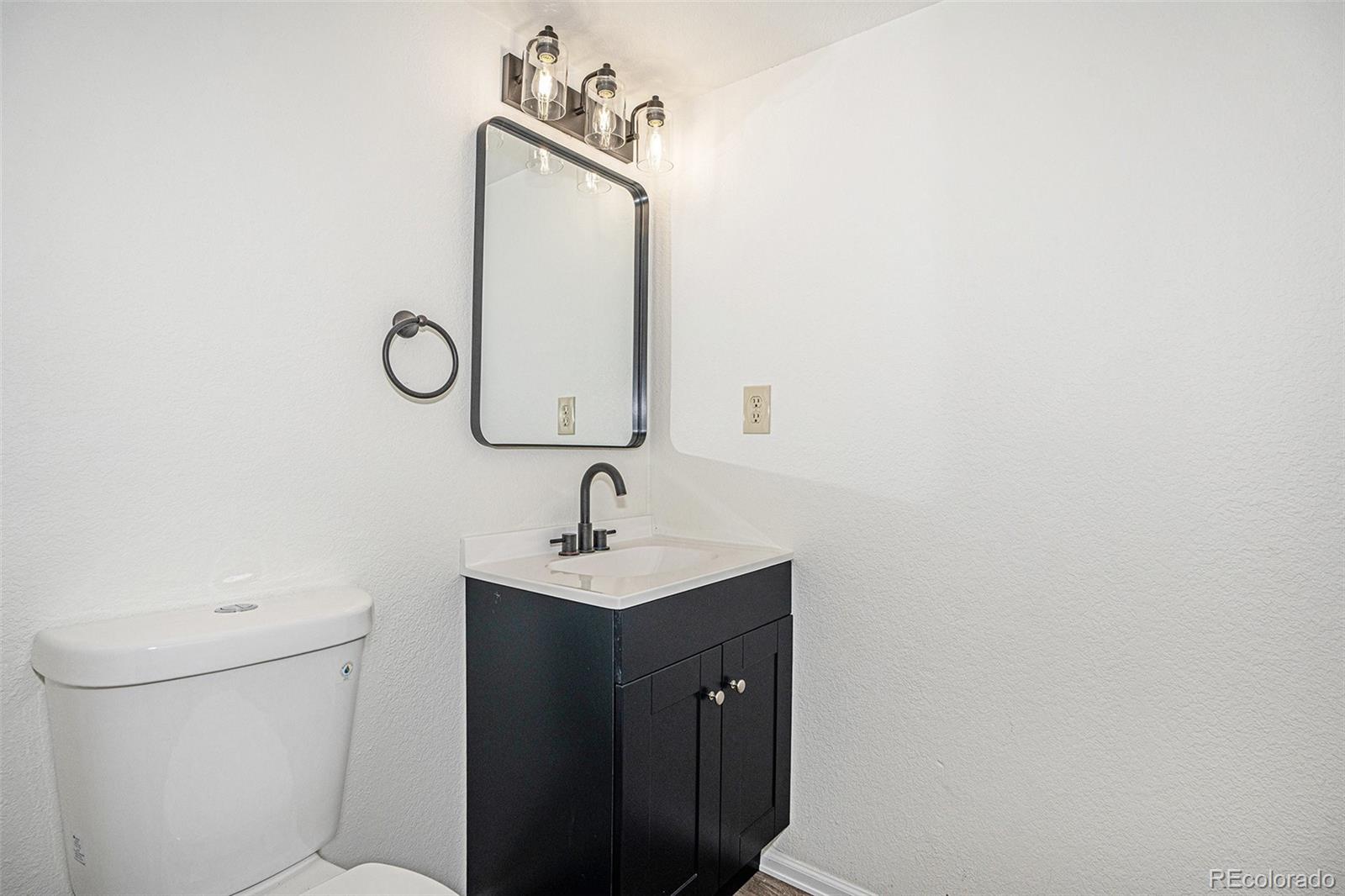6075 Castlewood Lane Colorado Springs, CO 80918 - Photo 11 of 23 a bathroom with a toilet sink and mirror