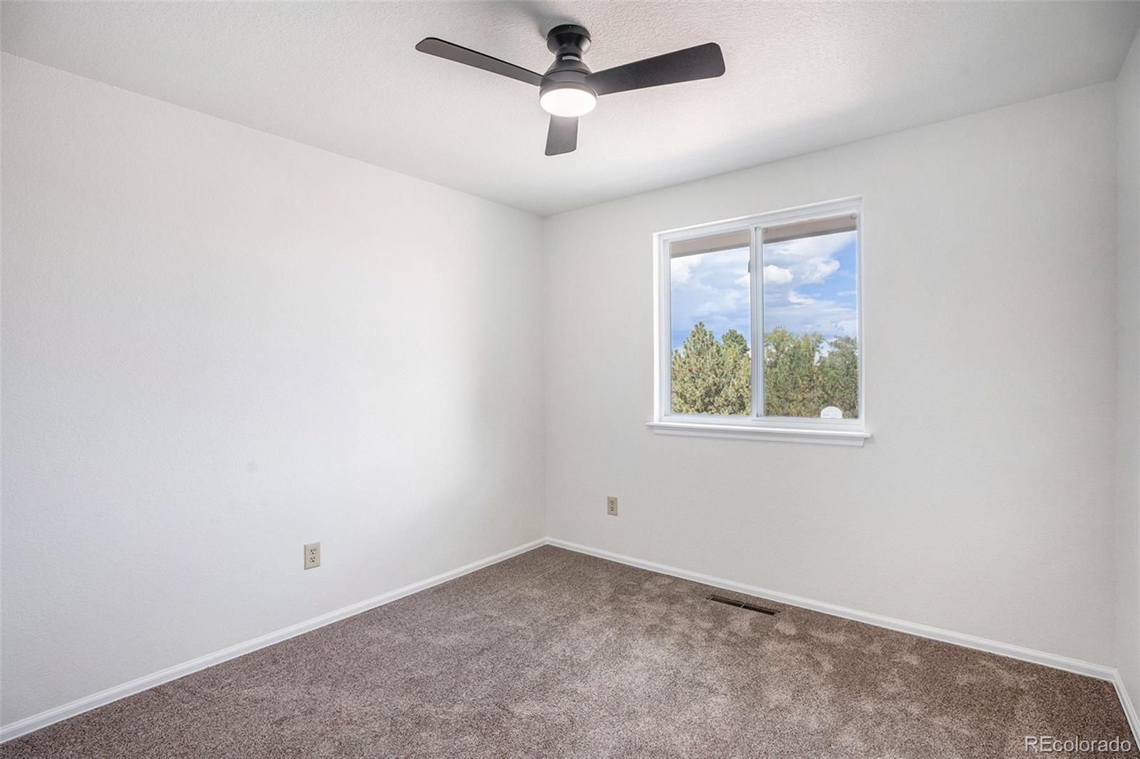 6075 Castlewood Lane Colorado Springs, CO 80918 - Photo 18 of 23 an empty room with a window and a ceiling fan
