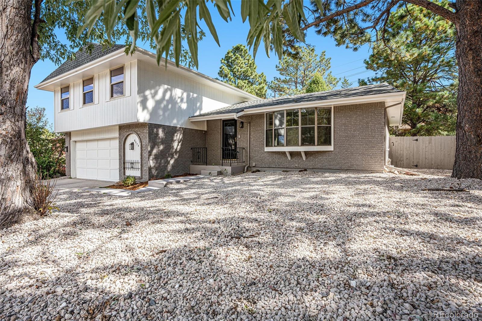 6075 Castlewood Lane Colorado Springs, CO 80918 - Photo 2 of 23 front view of a house with a yard