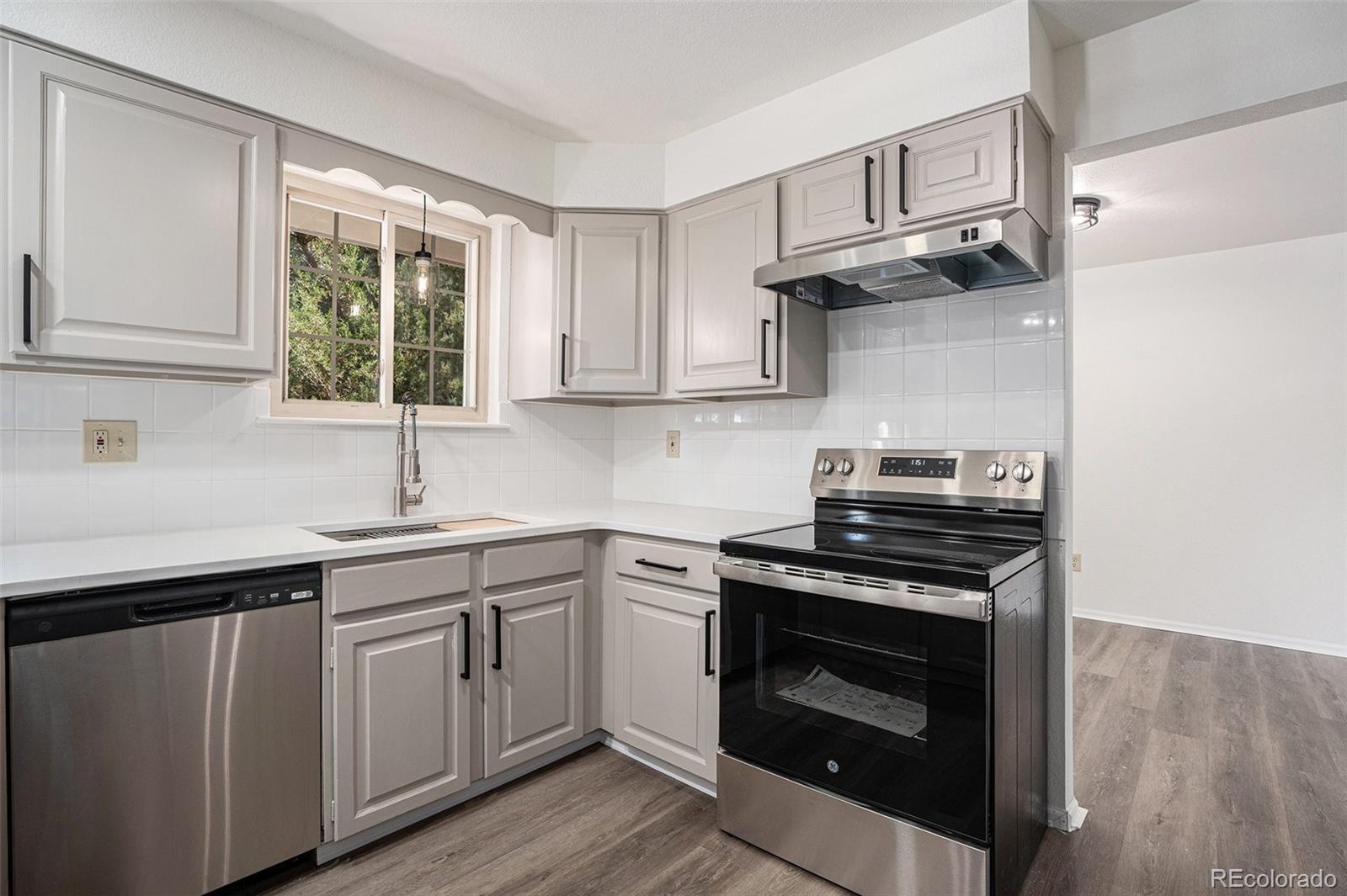 6075 Castlewood Lane Colorado Springs, CO 80918 - Photo 6 of 23 a kitchen with cabinets stainless steel appliances a sink and wooden floor
