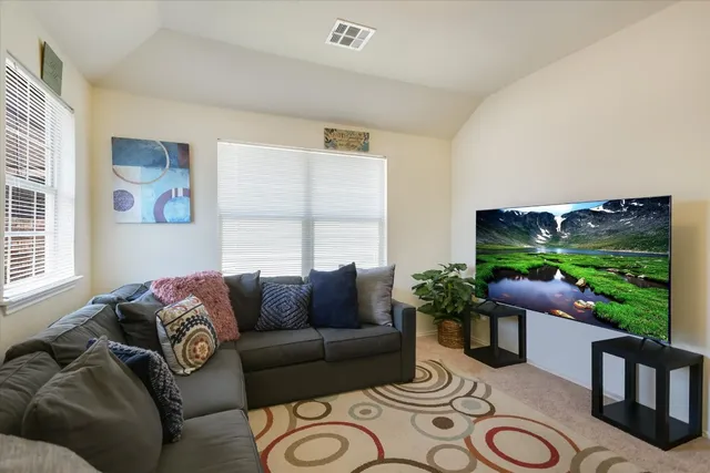 a living room with furniture and a floor to ceiling window
