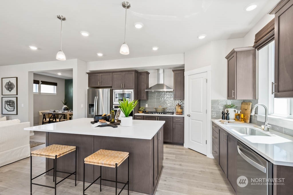 4414 228th Place South East, Unit MC5 Bothell, WA 98021 - Photo 12 of 33 a kitchen with kitchen island granite countertop a sink and white cabinets