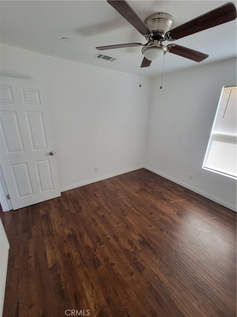 a view of a room with wooden floor and fan