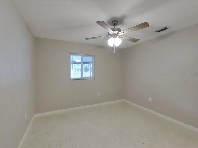 an empty room with a window and a fan