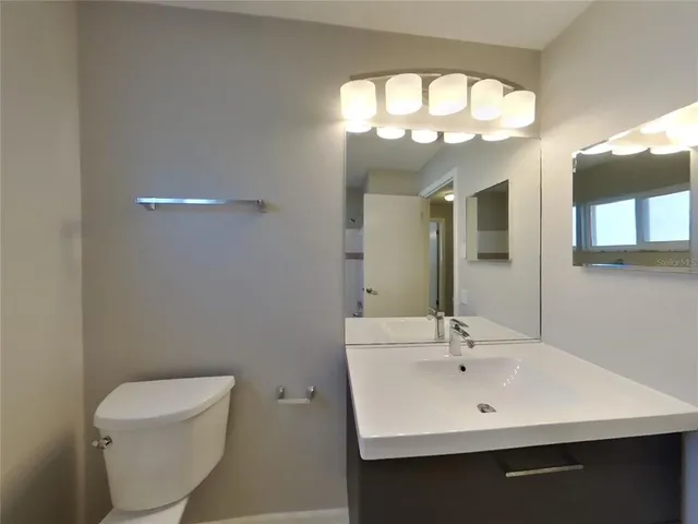 a bathroom with a toilet sink and mirror