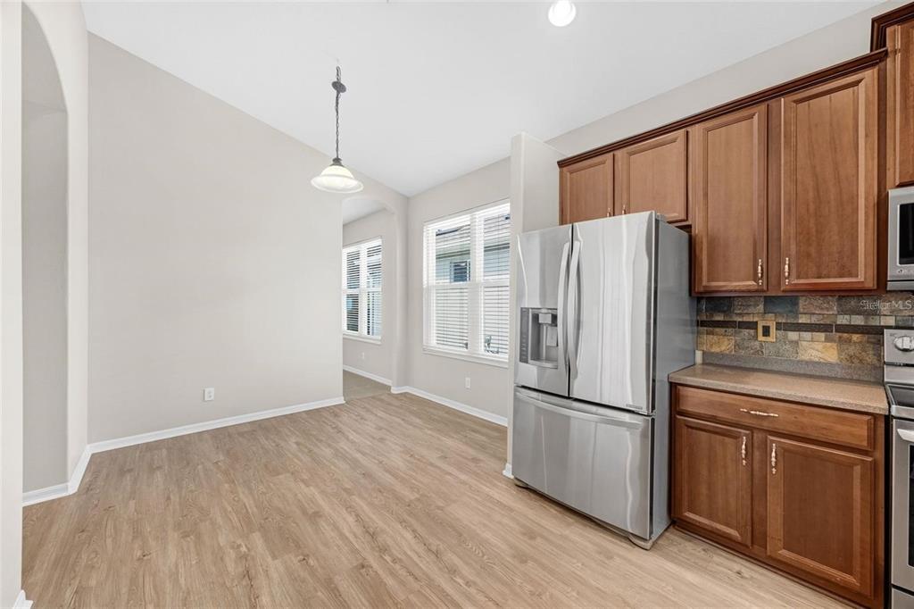 5124 Clover Mist Drive Apollo Beach, FL 33572 - Photo 12 of 52 a kitchen with stainless steel appliances granite countertop a refrigerator a microwave and wooden cabinets