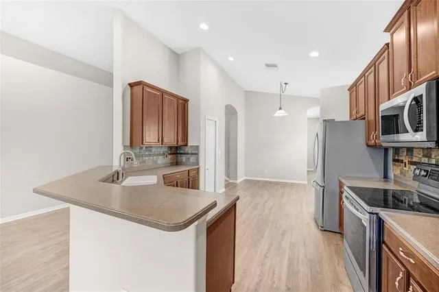 a kitchen with stainless steel appliances granite countertop a sink stove and refrigerator