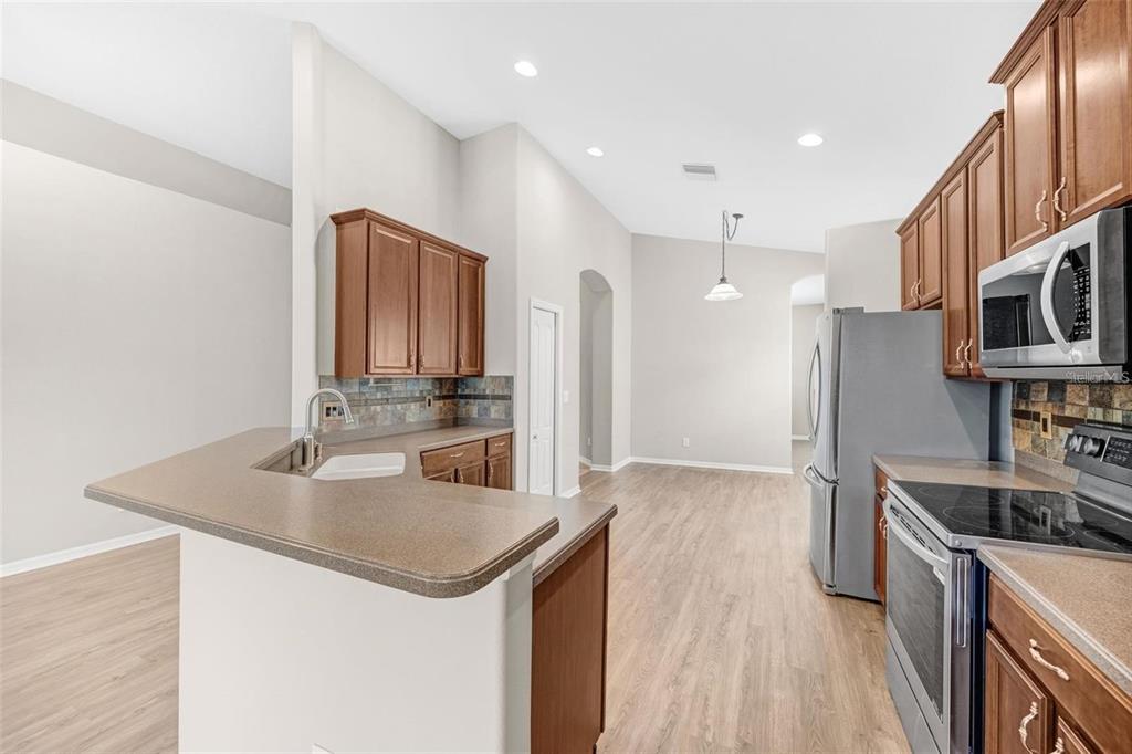 5124 Clover Mist Drive Apollo Beach, FL 33572 - Photo 15 of 52 a kitchen with stainless steel appliances granite countertop a sink stove and refrigerator