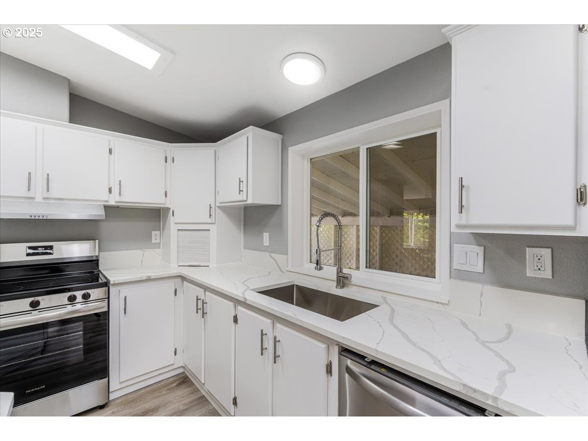 369 Gun Club Road, Unit 117 Woodland, WA 98674 - Photo 11 of 29 a kitchen that has a sink and a stove