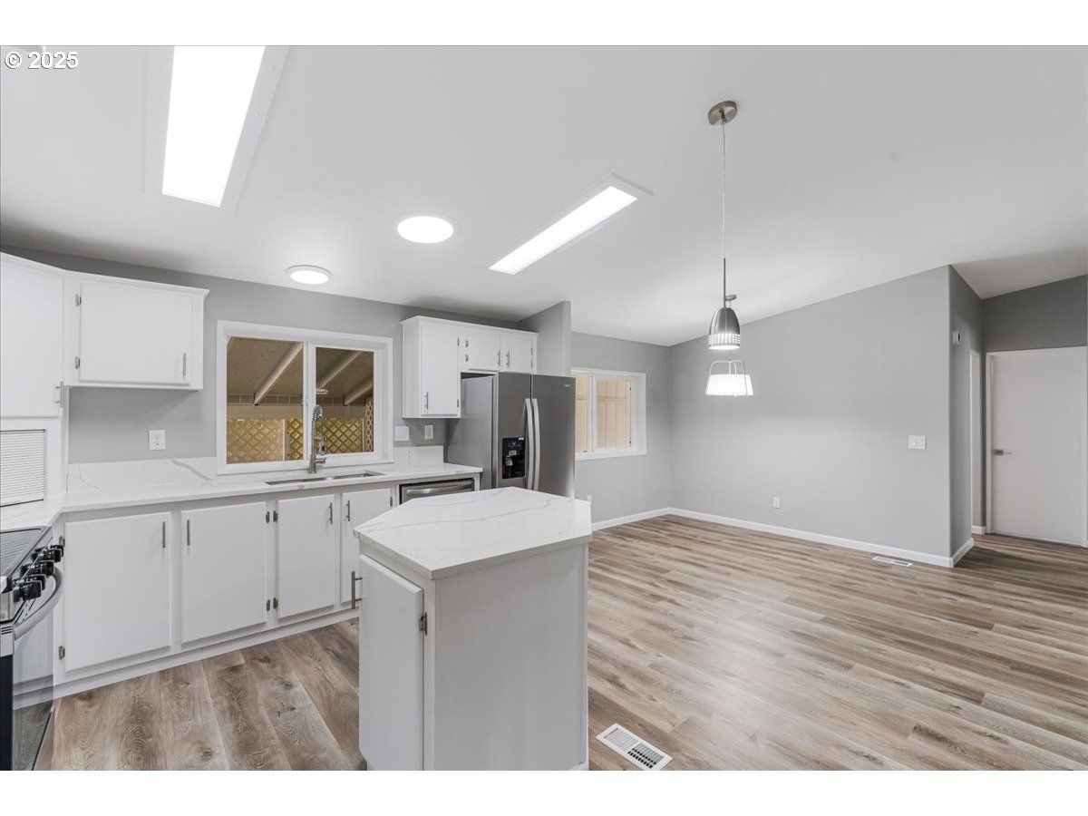 369 Gun Club Road, Unit 117 Woodland, WA 98674 - Photo 13 of 29 a kitchen with a sink cabinets and wooden floor