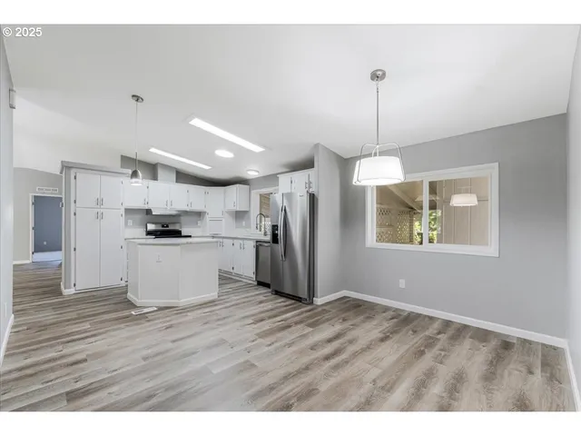 a view of kitchen with refrigerator microwave and wooden floor