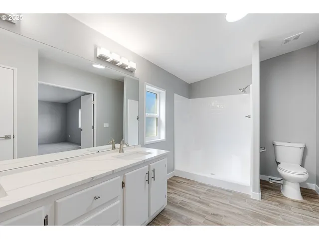 a bathroom with a granite countertop sink mirror and toilet