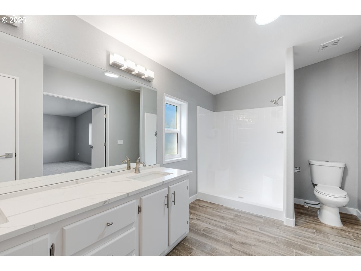 369 Gun Club Road, Unit 117 Woodland, WA 98674 - Photo 20 of 29 a bathroom with a granite countertop sink mirror and toilet