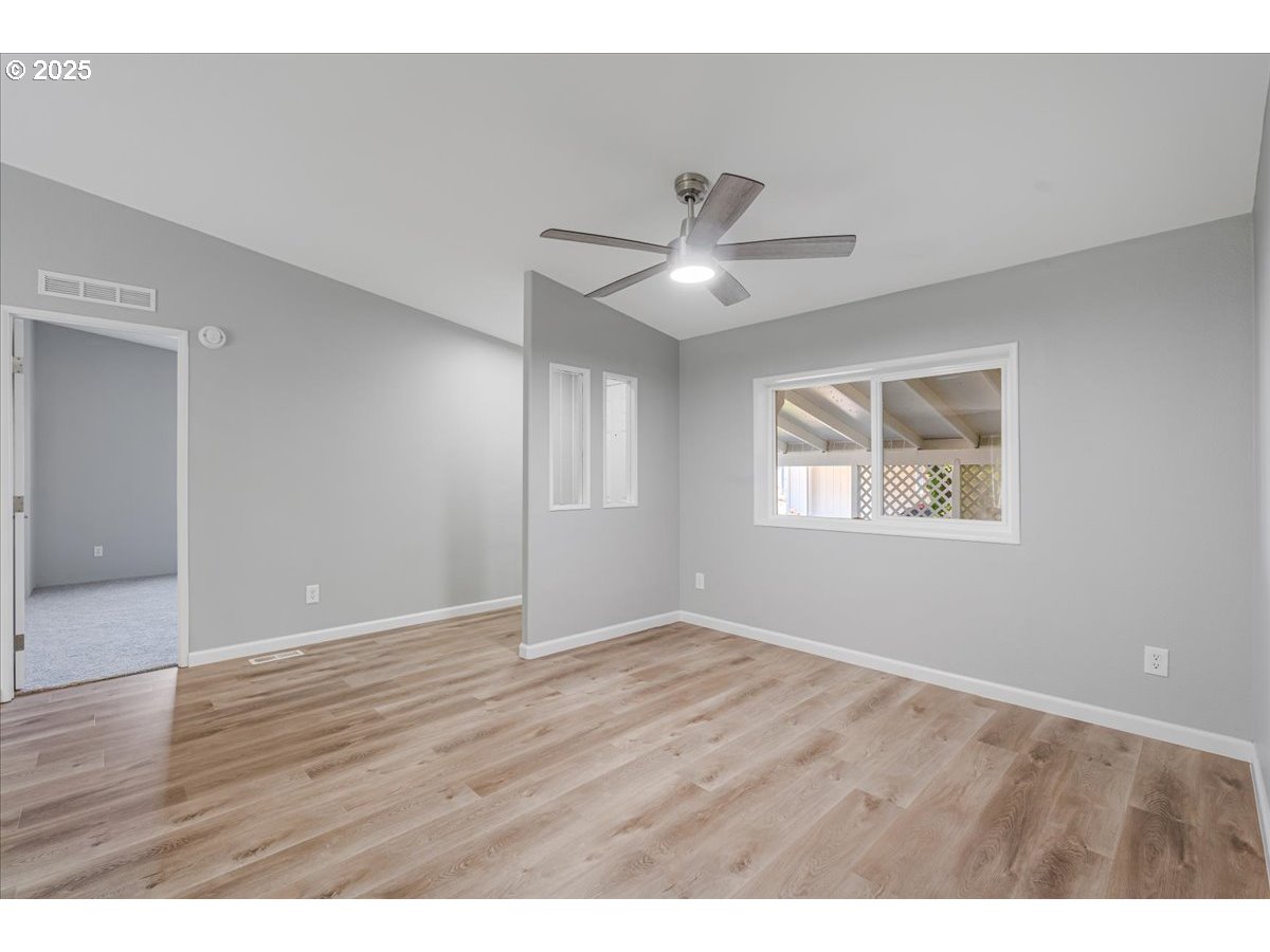 369 Gun Club Road, Unit 117 Woodland, WA 98674 - Photo 4 of 29 a view of an empty room with window and wooden floor