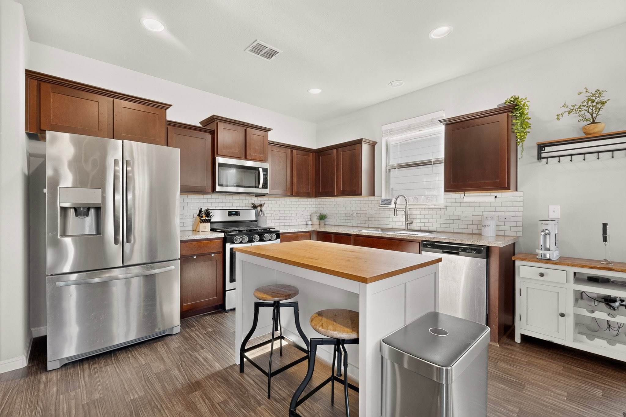 132 Wapiti Road Buda, TX 78610 - Photo 6 of 31 A well-equipped kitchen boasts rich cabinetry, stainless appliances, and a central island with seating.