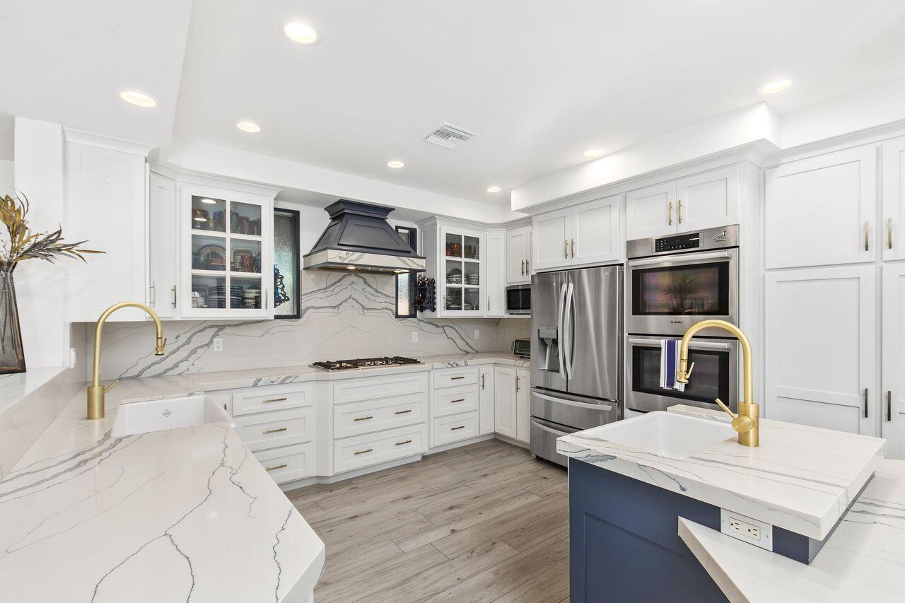 a kitchen with stainless steel appliances kitchen island granite countertop a refrigerator and a stove top oven