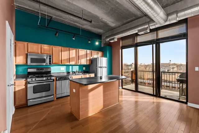 a kitchen with stainless steel appliances granite countertop a stove and a wooden floors