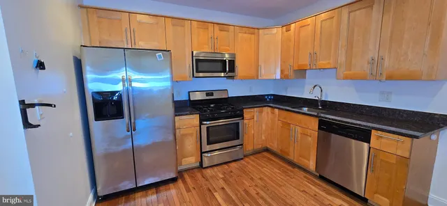 a kitchen with stainless steel appliances granite countertop a stove a sink and a refrigerator
