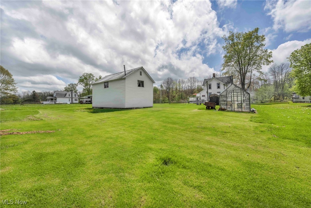 6873 Nichols Road Windham, OH 44288 - Photo 33 of 33 View of green lawn with an exterior structure and an outdoor structure
