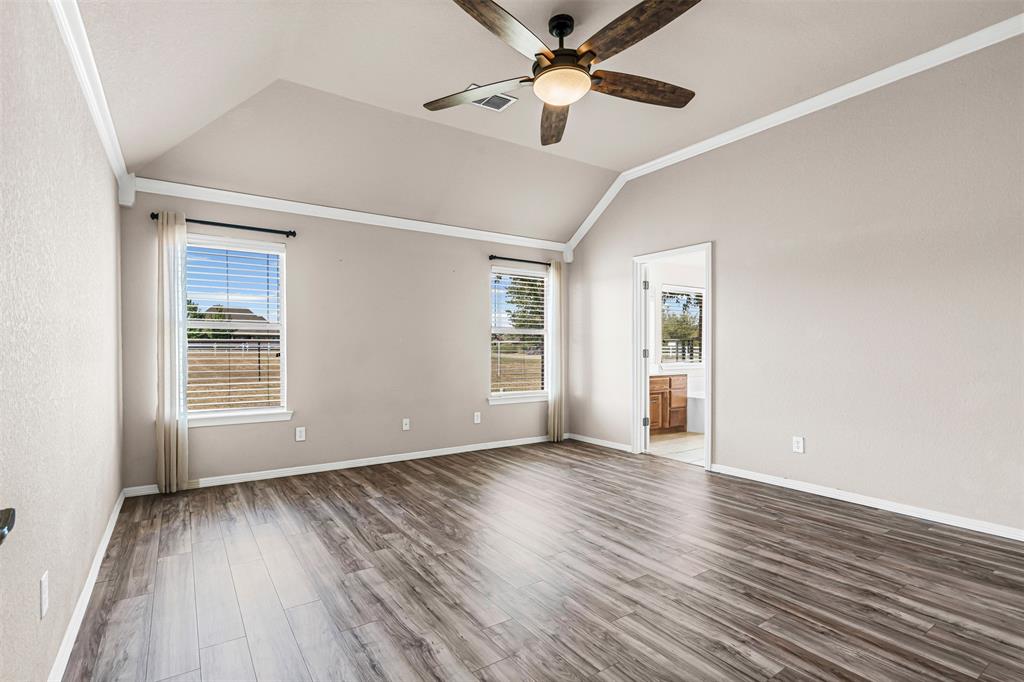 6009 Feather Wind Way Fort Worth, TX 76135 - Photo 11 of 19 an empty room with wooden floor chandelier fan and windows