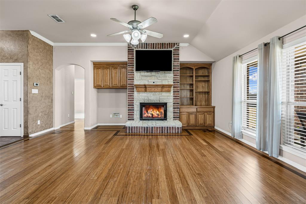 6009 Feather Wind Way Fort Worth, TX 76135 - Photo 6 of 19 an empty room with wooden floor fireplace cabinet and windows