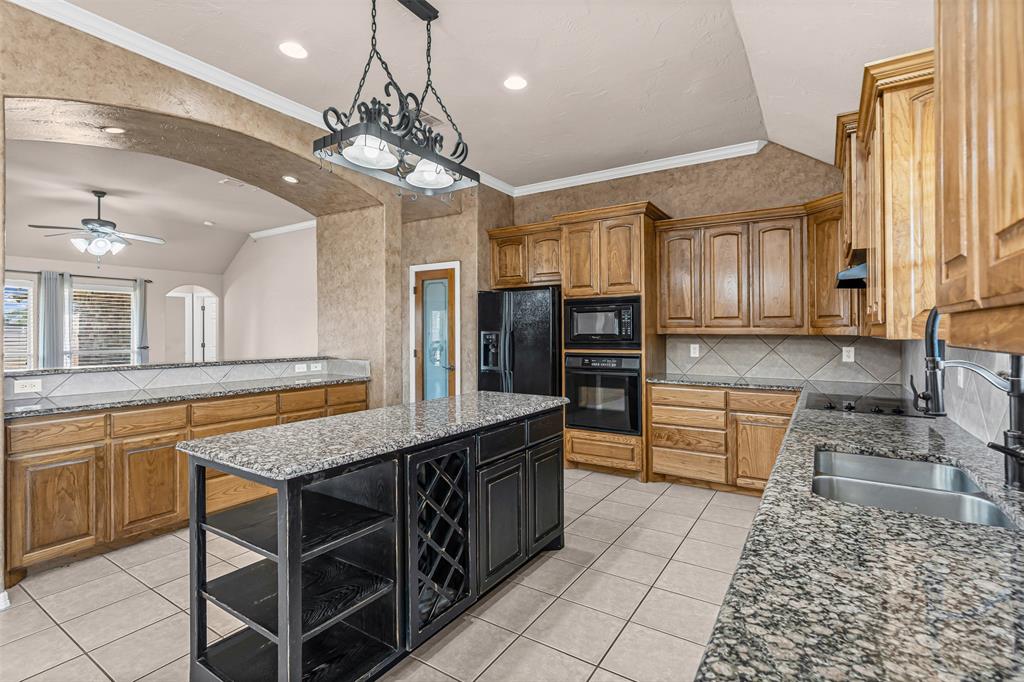 6009 Feather Wind Way Fort Worth, TX 76135 - Photo 9 of 19 a kitchen with stainless steel appliances granite countertop a sink counter space cabinets and a counter top space