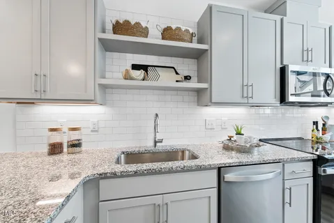 a kitchen with stainless steel appliances granite countertop a sink and cabinets
