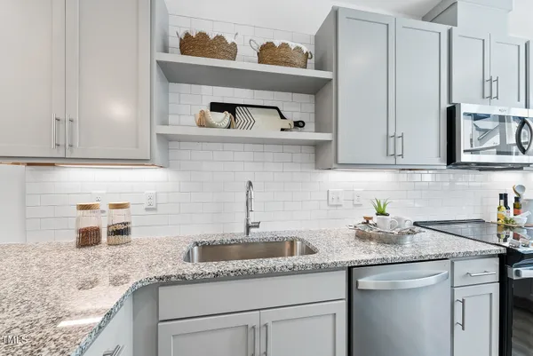a kitchen with stainless steel appliances granite countertop a sink and cabinets