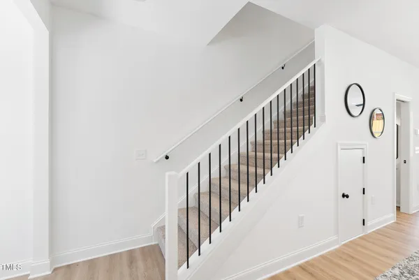 a view of a hallway with wooden floor and entryway