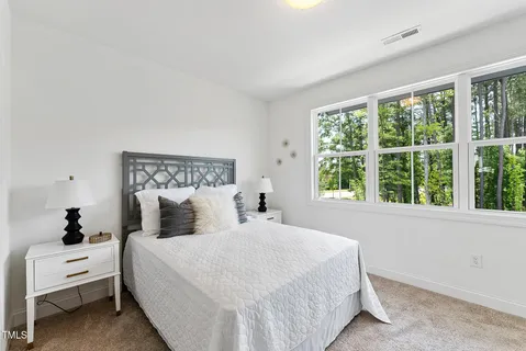 a bedroom with a white bed and a large window