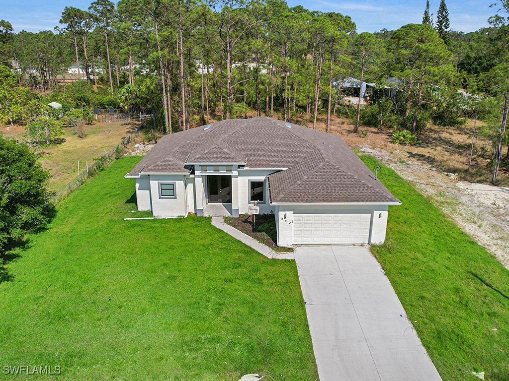 902 Williams Avenue Lehigh Acres, FL 33972 - Photo 1 of 30 a aerial view of a house next to a big yard and large trees