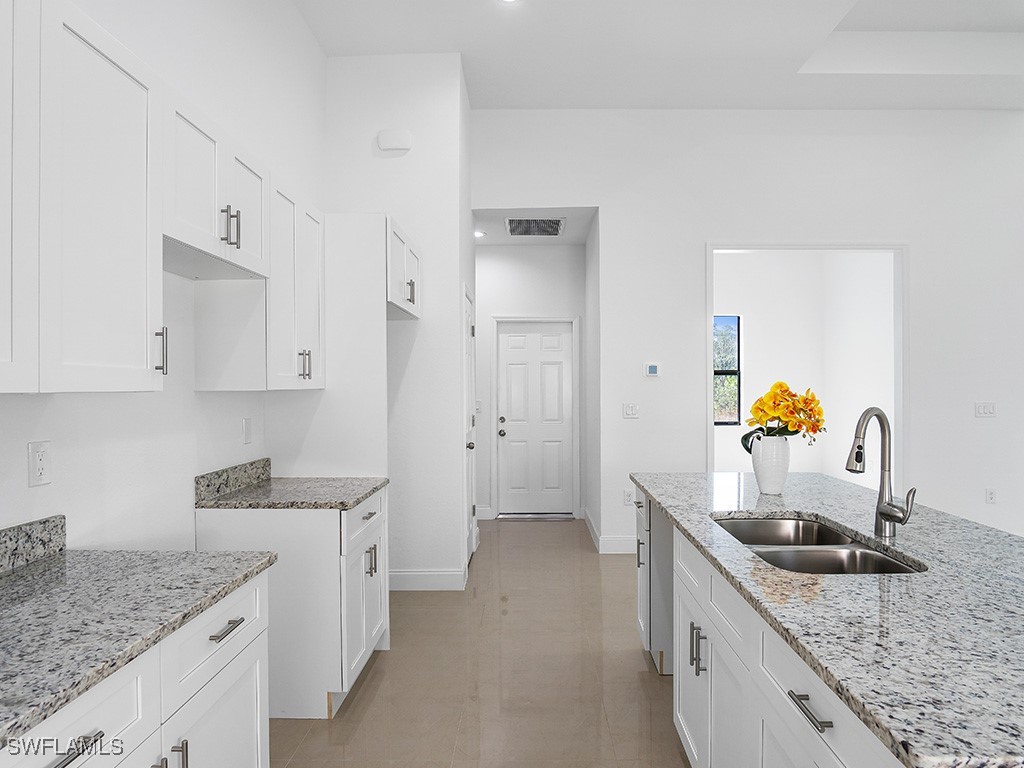 902 Williams Avenue Lehigh Acres, FL 33972 - Photo 11 of 30 a kitchen with stainless steel appliances granite countertop a sink stove and refrigerator